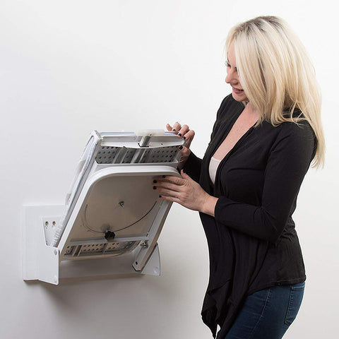 A person is operating a folding wall mounted ironing board